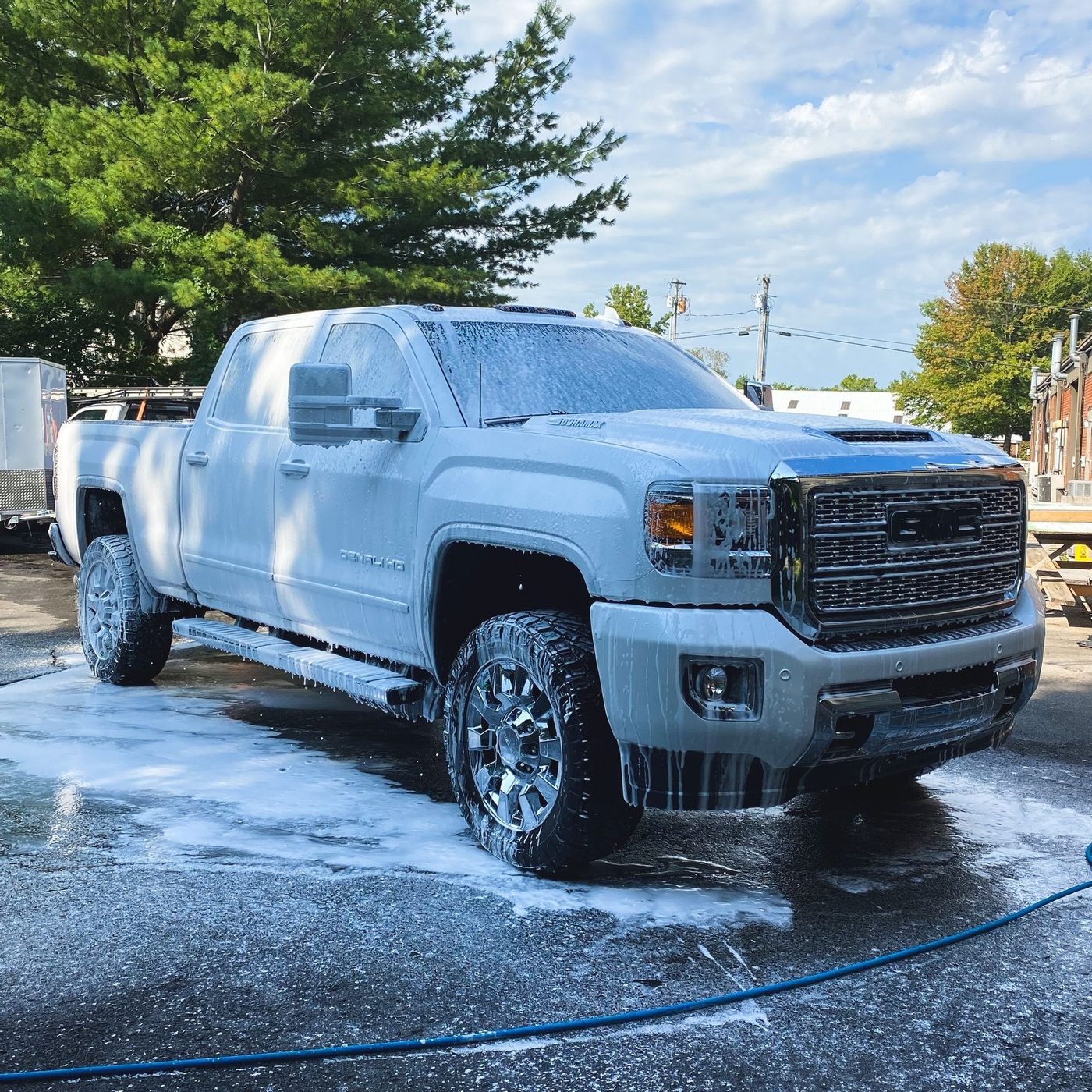 Camioneta pickup GMC blanca cubierta de espuma, lavado en exterior: lavado de flotillas